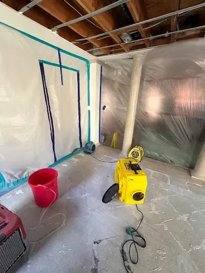 Plastic containment and an air mover in a room with the ceiling opened
