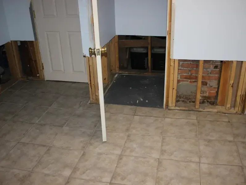 Drywall flood-cut along the lower walls of a tiled room while it dries